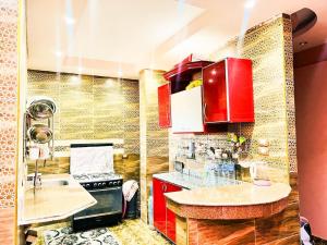 uma cozinha com armários vermelhos e uma bancada em شقة مميزة بجوار كورنيش النيل اسوان - عائلات فقط em Aswan