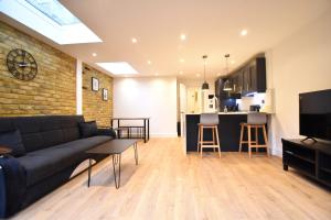 a living room with a couch and a kitchen at Stunning 2 bed apartment in London