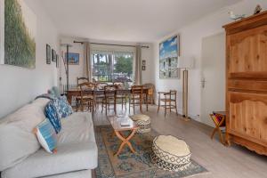 a living room with a couch and a dining room at Maison pour 6 - 1km de la plage - Hoomy in Le Pouliguen