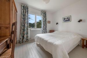 ein Schlafzimmer mit einem großen Bett und einem Fenster in der Unterkunft Sejour avec Hoomy au Pouliguen in Le Pouliguen
