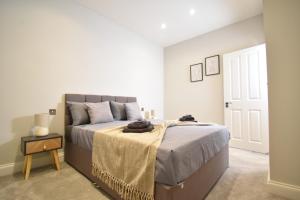 a bedroom with a bed with a blanket on it at Stunning 2 bed apartment in London
