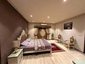 Schlafzimmer mit einem Bett, einem Tisch und Stühlen in der Unterkunft Spacious Haven in Islamabad