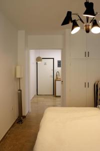1 dormitorio con 1 cama y pasillo con puerta en Luxurious studio apartment close to the beach and airport, en Porto Rafti