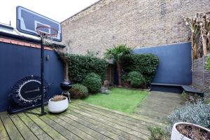 a backyard with a basketball hoop attached to a building at Veeve - A Vision in Blue in London