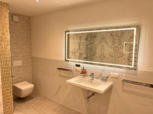 ein Bad mit einem Waschbecken, einem WC und einem Fenster in der Unterkunft db-rooms-i in Kassel