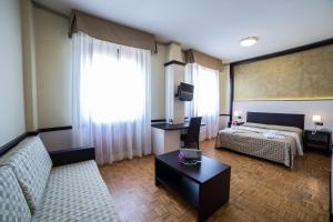 a hotel room with a couch and a bed at Hotel Astoria in Fidenza