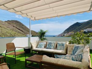 een patio met banken en uitzicht op het water bij Quinta Los Tizones in Santa Cruz de Tenerife