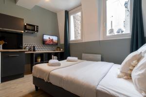 里爾的住宿－Lille Hypercentre - Nice and equipped studio!，一间带白色大床的卧室和一间厨房