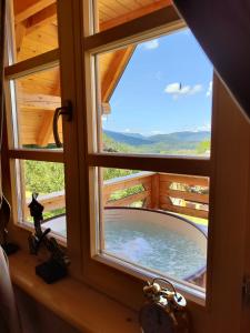 una ventana con vistas a una bañera en una cabaña en Sunset Lux Cottage Ravna Planina Pale - Jahorina en Pale