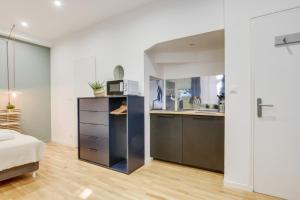 a kitchen with a sink and a microwave in a room at Lille Centre - Nice studio in Lille