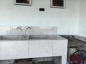 a kitchen with a sink in a white kitchen at Langkawi Homestay Family Suite 3Bed Room in Kuah +44 photos