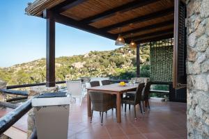 a dining room with a table and chairs on a patio at I Lecci 1 by Klodge in Olbia