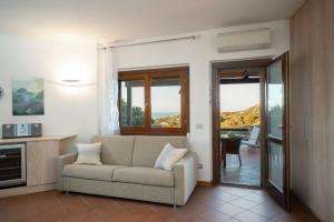 a living room with a couch and a balcony at I Lecci 1 by Klodge in Olbia