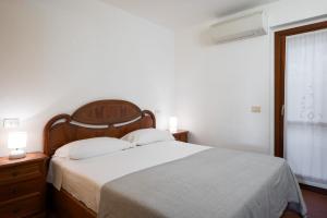 a bedroom with a large bed and a window at I Lecci 1 by Klodge in Olbia