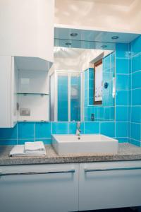a blue bathroom with a sink and a mirror at I Lecci 1 by Klodge in Olbia +24 photos