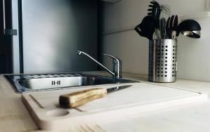 a kitchen counter with a sink and a utensil at Lighthouse Hostel & Rooms in Rīga