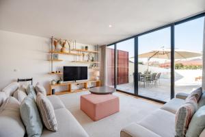 a living room with a white couch and a tv at VIVA Serralves Patio in Porto