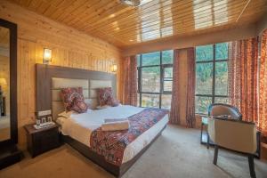 1 dormitorio con 1 cama, escritorio y ventanas en The Hotel Influence, en Pahalgām