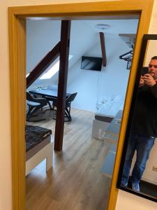 a man taking a picture of himself in a mirror at FeWo WIEKO Plauen Leibnizstr. H1, DG rechts in Plauen +7 photos