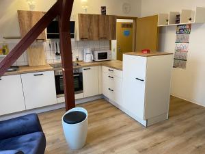 a kitchen with white cabinets and a blue couch at FeWo WIEKO Plauen Leibnizstr. H1, DG rechts in Plauen