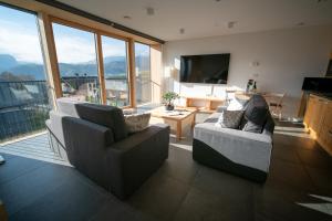 uma sala de estar com 2 cadeiras e uma televisão de ecrã plano em eco boutique hotel AMS Beagle em Bled