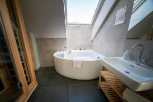 a bathroom with a large tub and a sink at eco boutique hotel AMS Beagle in Bled