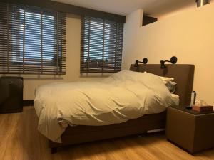 1 dormitorio con 1 cama grande y 2 ventanas en Verrassende ruime Stadswoning nabij station, centrum met unieke tuin., en Venlo