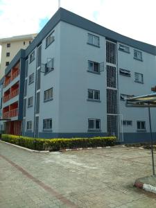 a large white building with a lot of windows at The Emem Apartment Collections in Lagos