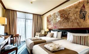 una camera d'albergo con 2 letti e una scrivania di Platinum Hotel and Casino Bansko a Bansko