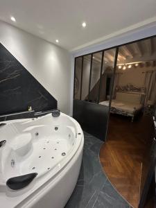 - Baño con bañera blanca y dormitorio en Château Le Fournel, en La Fouillouse