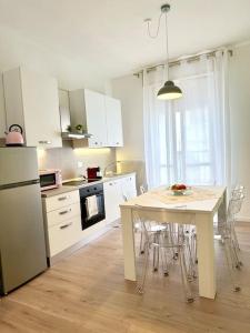 a kitchen with a table and a white refrigerator at Casa in centro storico Lago di Garda in Castelnuovo del Garda