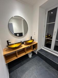 baño con 2 lavabos y espejo grande en Château Le Fournel, en La Fouillouse