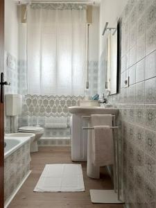 Baño blanco con lavabo y aseo en Casa in centro storico Lago di Garda, en Castelnuovo del Garda