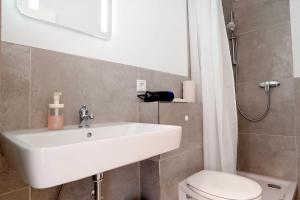 a bathroom with a white sink and a toilet at Schöne Apartments in Bad Rothenfelde I private Parkplätze mit Ladesäulen I home2share in Bad Rothenfelde