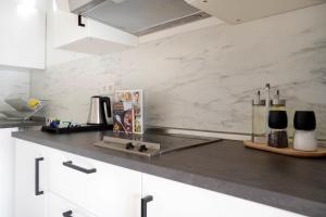 a kitchen with white marble walls and a counter top at Schöne Apartments in Bad Rothenfelde I private Parkplätze mit Ladesäulen I home2share in Bad Rothenfelde