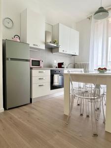 a kitchen with a refrigerator and a table with chairs at Casa in centro storico Lago di Garda in Castelnuovo del Garda
