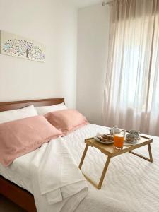 Una cama con una mesa con una bandeja de comida. en Casa in centro storico Lago di Garda, en Castelnuovo del Garda