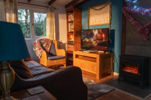 a living room with a couch and a television at Bunny Lodge 30 - Riverside in Builth Wells