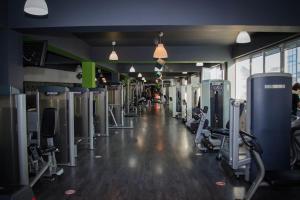 een fitnessruimte met rijen loopbanden en machines bij PentGarden penthouse jacuzzi in Târgu Jiu