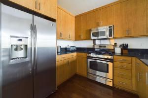 a kitchen with stainless steel appliances and wooden cabinets at Oakland 1br w balcony nr dining shops bart SFO-1552 in Oakland