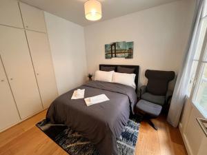een slaapkamer met een bed en een stoel erin bij Beautiful Apartment in City Center in Bordeaux