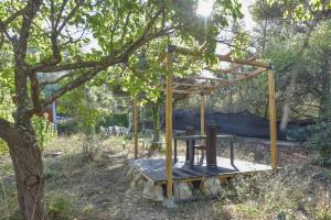 una estructura de madera sentada bajo un árbol en Wood Chalet 1 Monaco Forest La Turbie - Sleeps 5 people, en La Turbie