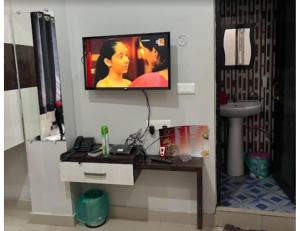 a tv on a wall in a bathroom with a desk at Hotel Sonar Gaon, Agartala in Agartala