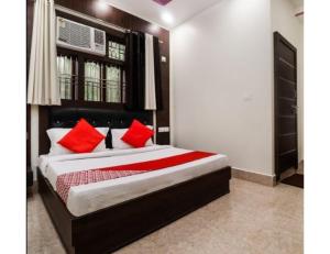 um quarto com uma cama grande e almofadas vermelhas em Hotel Sonar Gaon, Agartala em Agartala
