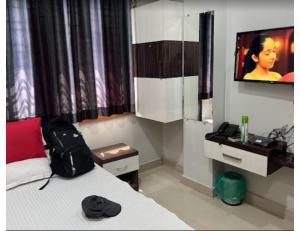 a bedroom with a bed with a backpack on it at Hotel Sonar Gaon, Agartala in Agartala