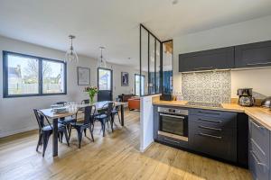 a kitchen and dining room with a table and chairs at Nouelig - A 150m de la plage de la Ria in Plouhinec