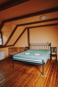 a bed in a room with a wooden floor at Bělský Dvůr in Bělý