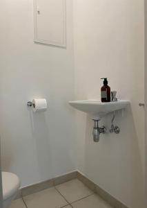 a white bathroom with a sink and a toilet at Kom tot rust in een heerlijk verblijf - Toplocatie met zonneterras! in Nieuwpoort
