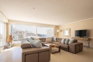 ein Wohnzimmer mit einem Sofa und einem TV in der Unterkunft Buccara Altea Beach Villas in Altea