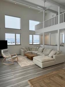 a white living room with a couch and a chair at Mountain Villa ニセコ in Kutchan
